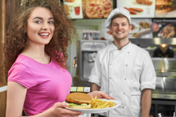 woman-keeping-plate-with-fast-food-smiling-cafe